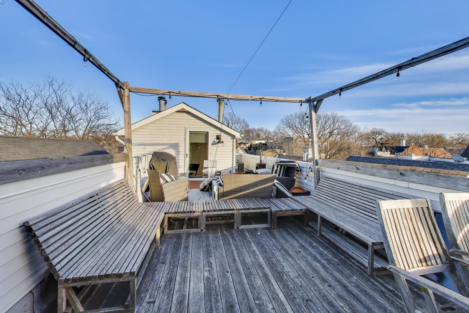 3442 North Damen Avenue, Unit 3 Chicago, IL 60618 - Photo 24 of 34 a view of a roof deck with table and chairs a barbeque with wooden floor and fence