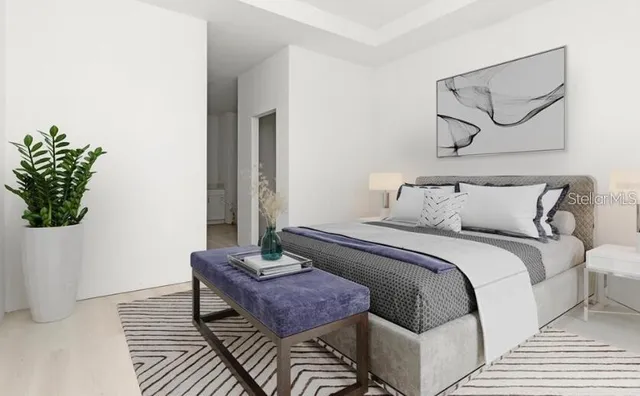 a bedroom with a bed and a potted plant