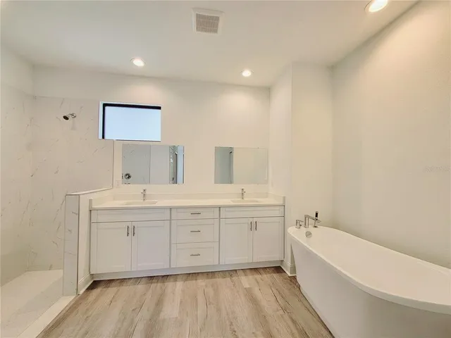 a bathroom with a tub sink and mirror