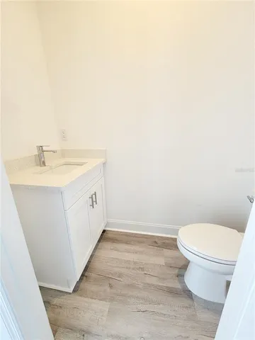 a bathroom with a granite countertop toilet and a sink