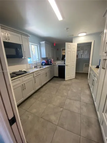 a kitchen with a sink a stove top oven and cabinets