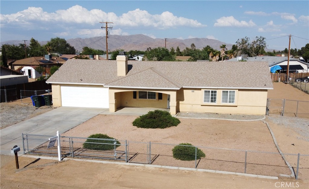 a aerial view of a house with a garden and parking space