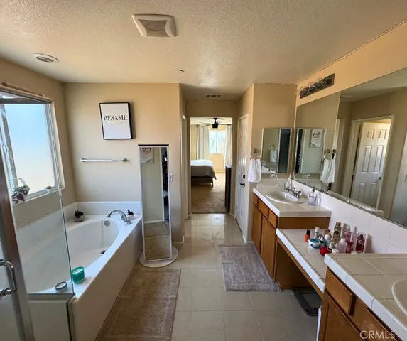 a bathroom with a tub sink and mirror