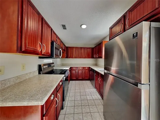 a kitchen with stainless steel appliances granite countertop a refrigerator and a sink