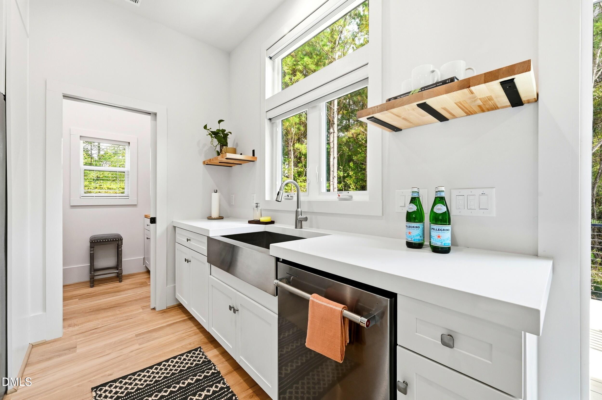1459 Hawkins Road Hurdle Mills, NC 27541 - Photo 12 of 36 a kitchen with stainless steel appliances white cabinets a stove a sink and a window