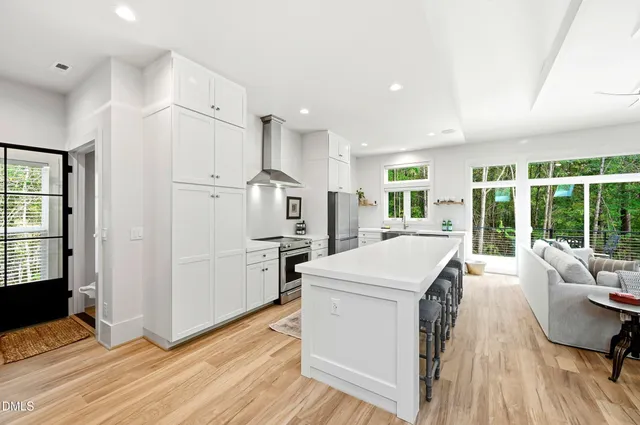 a open kitchen with white cabinets and wooden floor