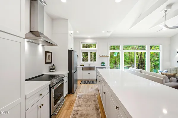 a large kitchen with kitchen island a large window cabinets and stainless steel appliances