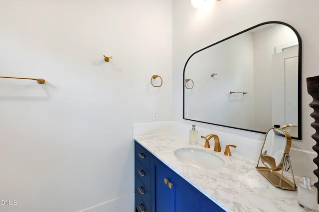 a bathroom with a granite countertop sink and a mirror