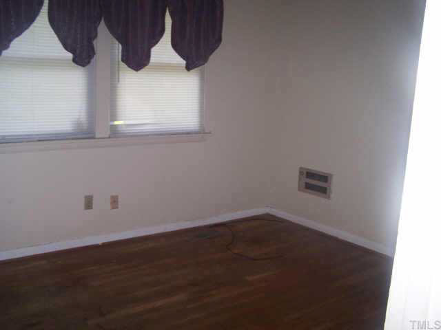2717 Wyncote Drive Raleigh, NC 27603 - Photo 4 of 9 an empty room with wooden floor and windows