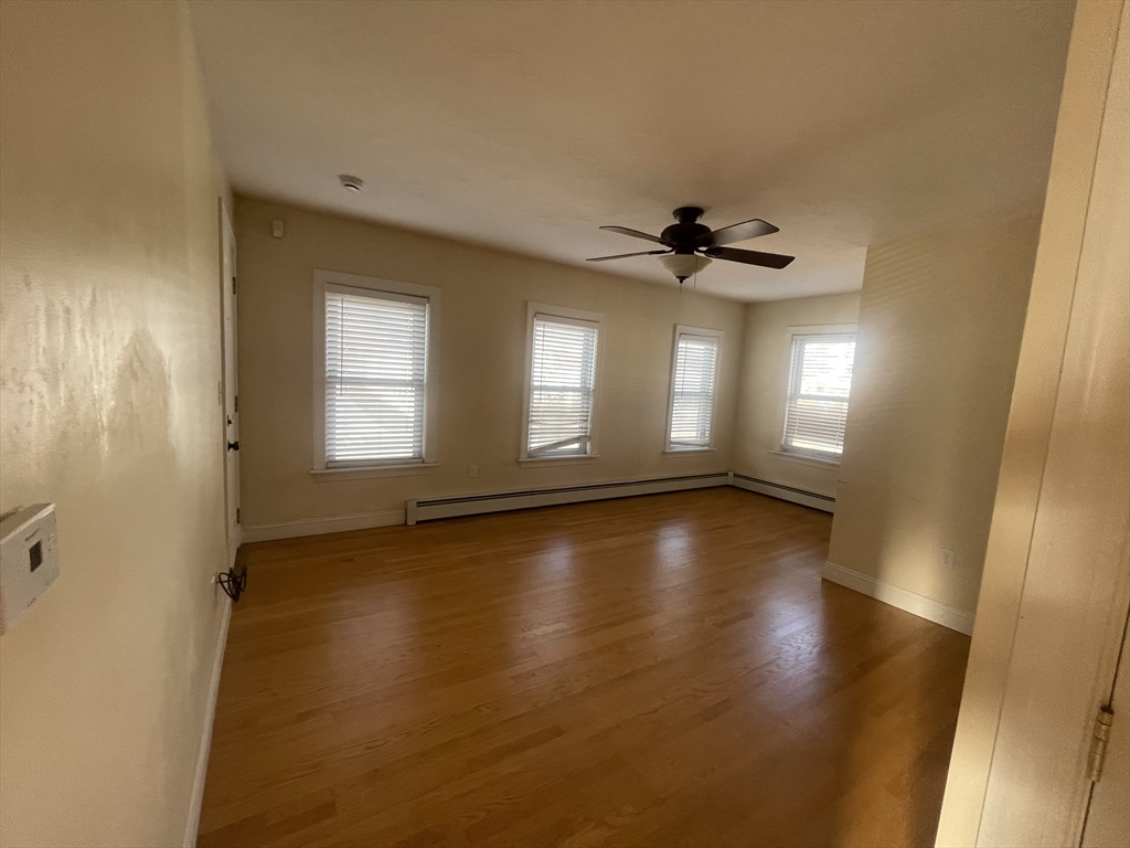 363 Shrewsbury Street, Unit 2 Worcester, MA 01604 - Photo 3 of 20 a view of empty room with wooden floor and fan