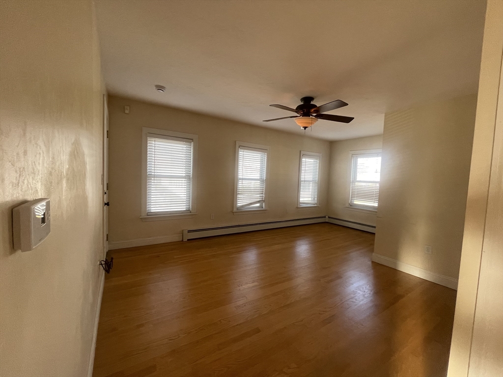 363 Shrewsbury Street, Unit 2 Worcester, MA 01604 - Photo 5 of 20 an empty room with wooden floor and windows