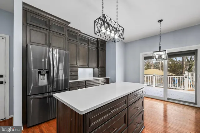 a kitchen with kitchen island a large counter and stainless steel appliances
