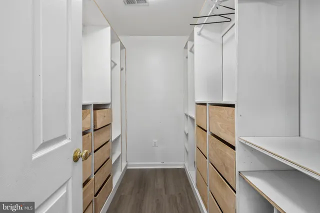 a view of walk in closet with empty racks