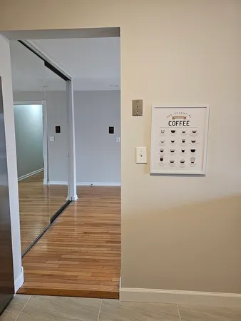 a view of a hallway with wooden floor and cabinet