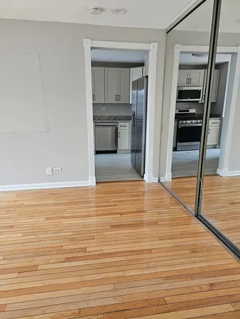 a view of empty room with wooden floor