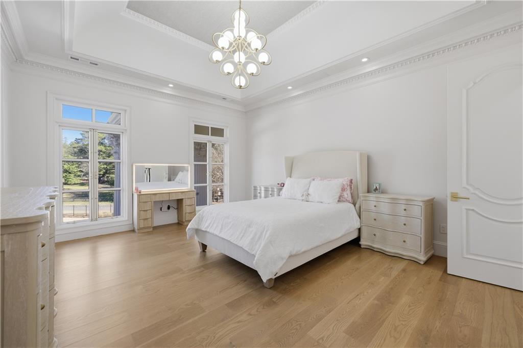 10450 Belladrum Alpharetta, GA 30022 - Photo 42 of 95 a spacious bedroom with a bed and a chandelier