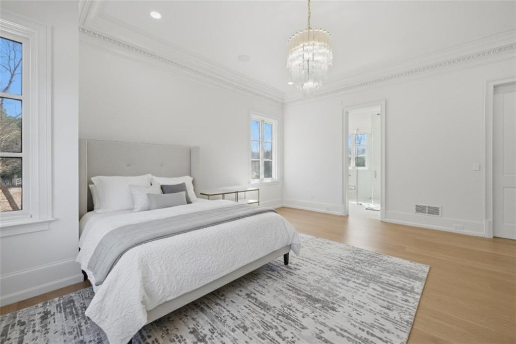 10450 Belladrum Alpharetta, GA 30022 - Photo 52 of 95 a spacious bedroom with a bed and a chandelier