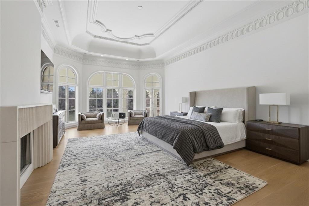10450 Belladrum Alpharetta, GA 30022 - Photo 69 of 95 a spacious bedroom with a bed a couch and chandelier