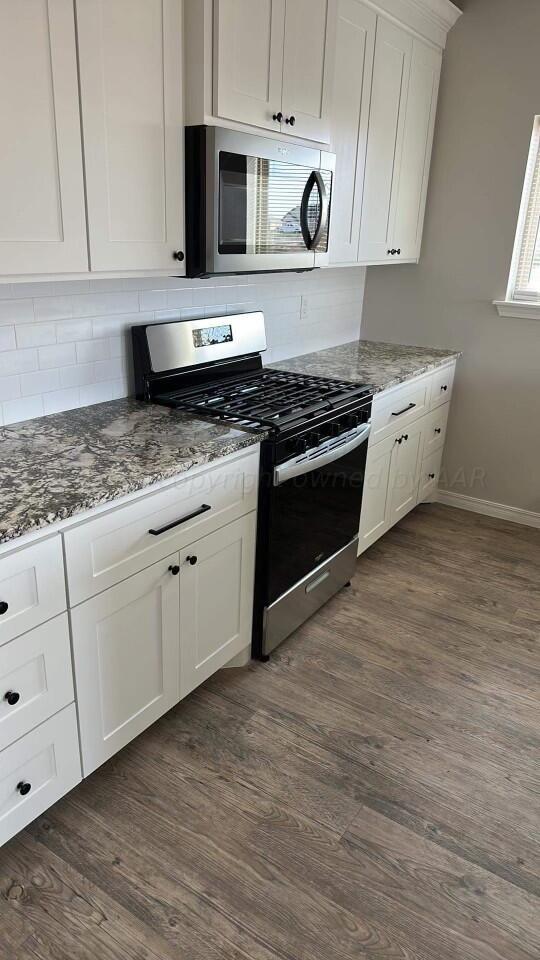 14007 Hawksbeard Place Amarillo, TX 79119 - Photo 5 of 18 a kitchen with stainless steel appliances granite countertop a stove a sink and a microwave