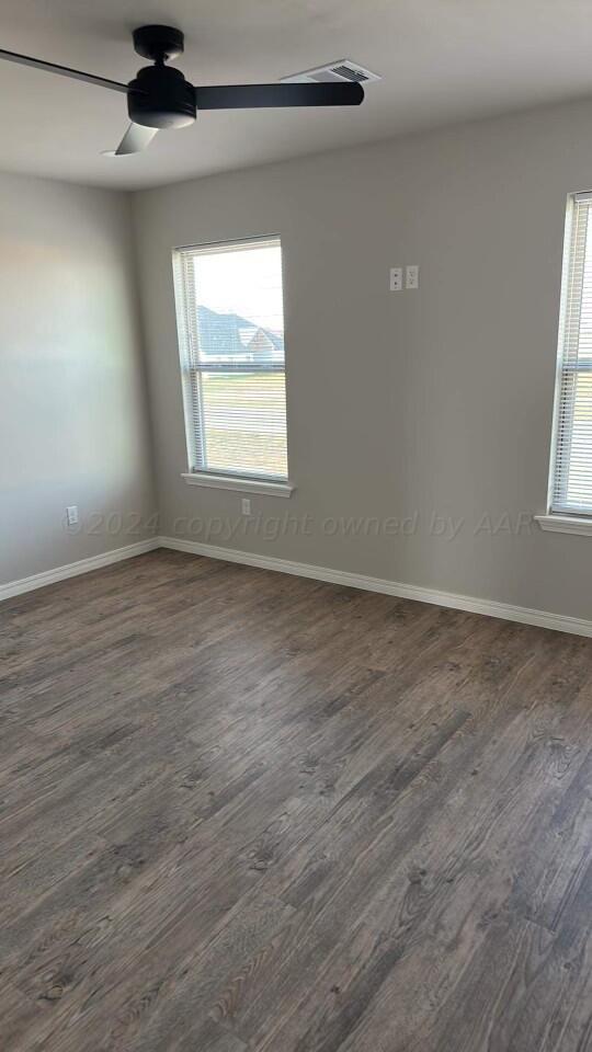14007 Hawksbeard Place Amarillo, TX 79119 - Photo 8 of 18 an empty room with wooden floor chandelier fan and windows
