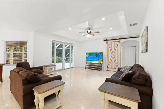 a living room with furniture and a ceiling fan