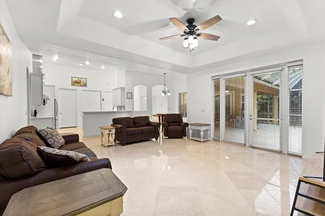 a living room with furniture a flat screen tv and a large window