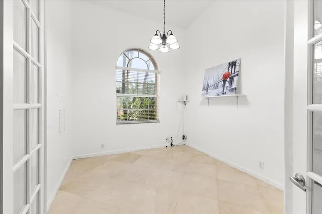 an empty room with a window and a chandelier