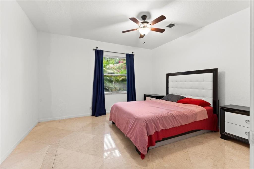Undisclosed Address Davie, FL 33314 - Photo 26 of 38 a bedroom with a large bed and a chandelier