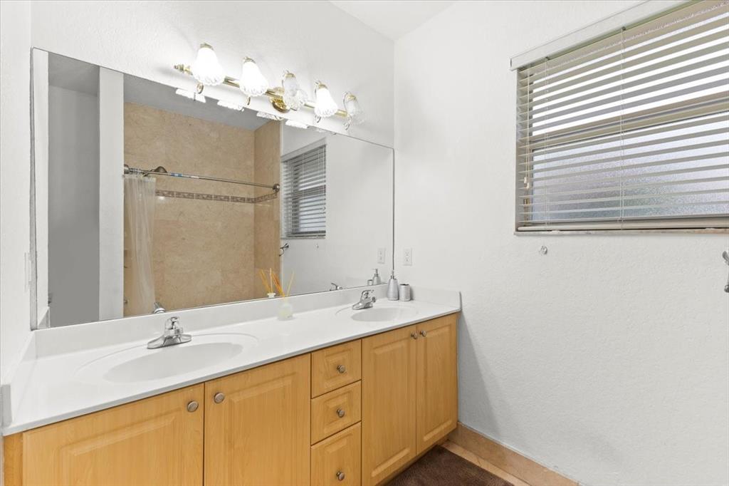Undisclosed Address Davie, FL 33314 - Photo 29 of 38 a bathroom with a double vanity sink and a mirror
