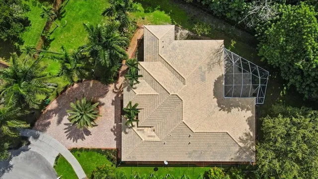 an aerial view of a house with a yard and a large pool