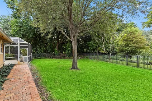 an aerial view of residential houses with outdoor space and trees