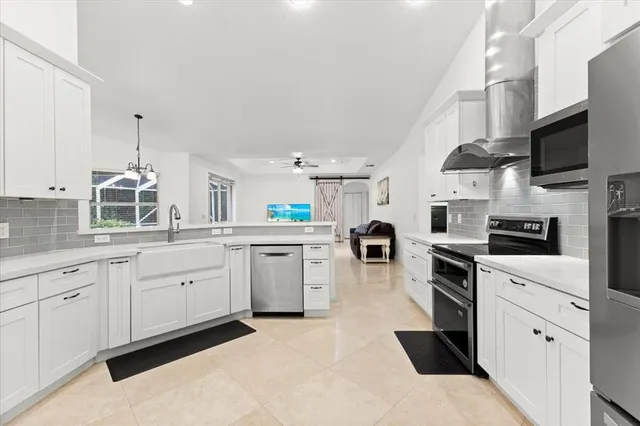 a kitchen with sink cabinets and white appliances