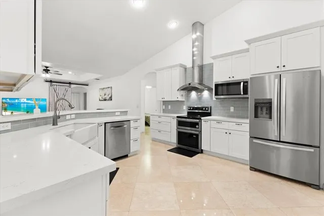 a kitchen with white cabinets and sink
