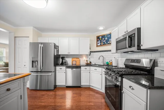 a kitchen with granite countertop a refrigerator stove and microwave