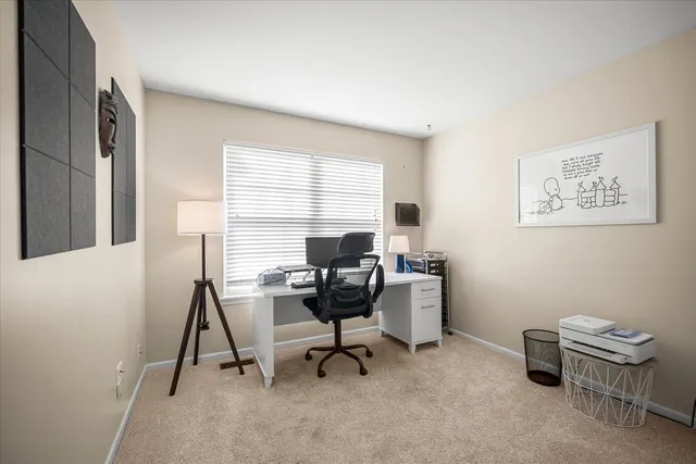 a view of a workspace with furniture and a window