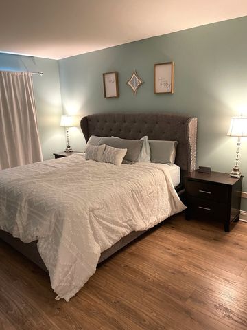 a large bed sitting in a bedroom next to a lamp