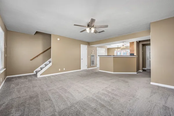 a view of empty room with wooden floor and ceiling fan