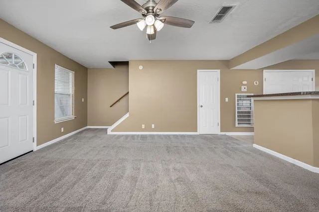 an empty room with fan and windows