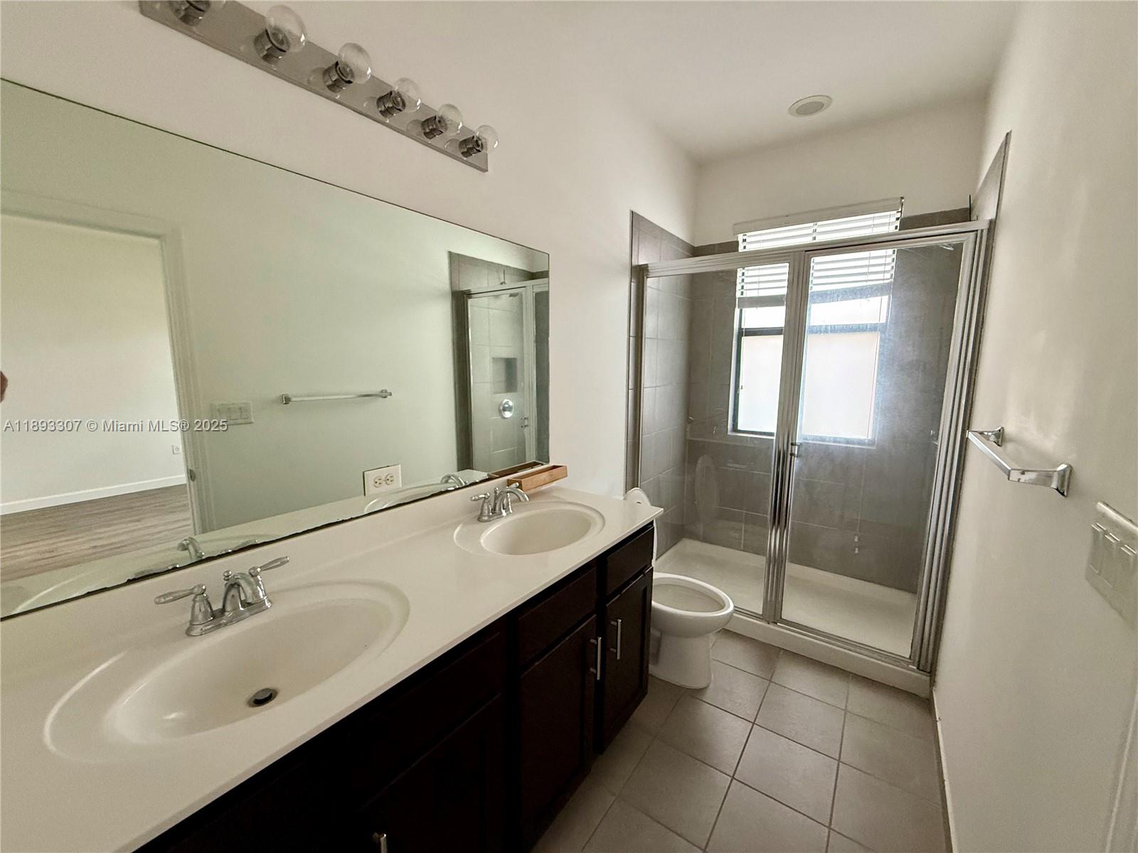 1075 Northwest 33rd Manor Pompano Beach, FL 33064 - Photo 13 of 27 a bathroom with a double vanity sink mirror and shower
