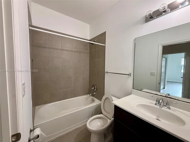a bathroom with a bathtub shower sink vanity and toilet