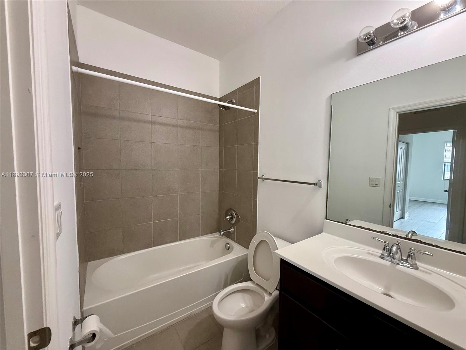 1075 Northwest 33rd Manor Pompano Beach, FL 33064 - Photo 19 of 27 a bathroom with a bathtub shower sink vanity and toilet