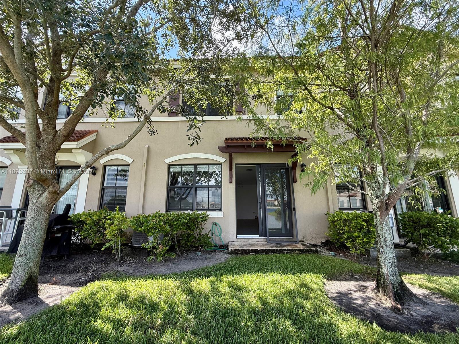 1075 Northwest 33rd Manor Pompano Beach, FL 33064 - Photo 21 of 27 a front view of a house with yard and green space