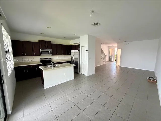 a kitchen with stainless steel appliances a refrigerator sink and microwave
