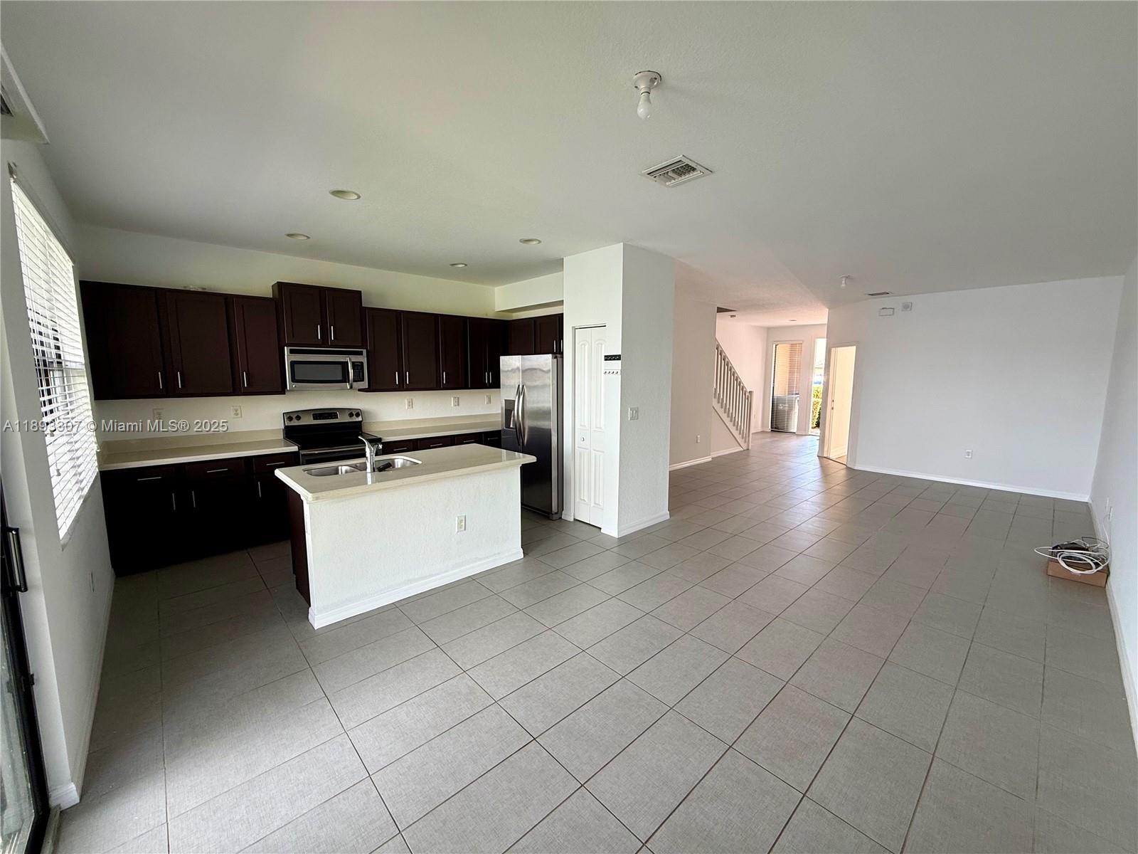 1075 Northwest 33rd Manor Pompano Beach, FL 33064 - Photo 5 of 27 a kitchen with stainless steel appliances a refrigerator sink and microwave