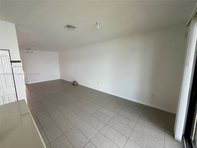 an empty room with wooden floor and cabinet