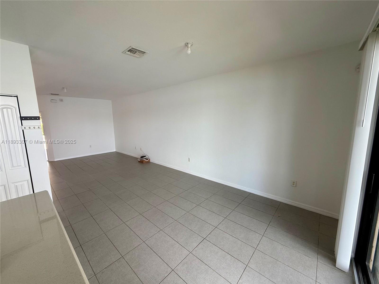 1075 Northwest 33rd Manor Pompano Beach, FL 33064 - Photo 7 of 27 an empty room with wooden floor and cabinet