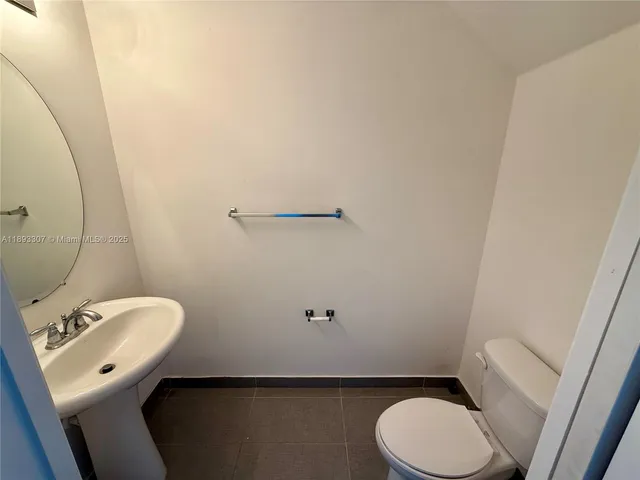 a bathroom with a toilet a sink and mirror
