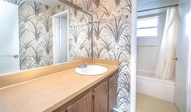 a bathroom with a granite countertop sink and a mirror