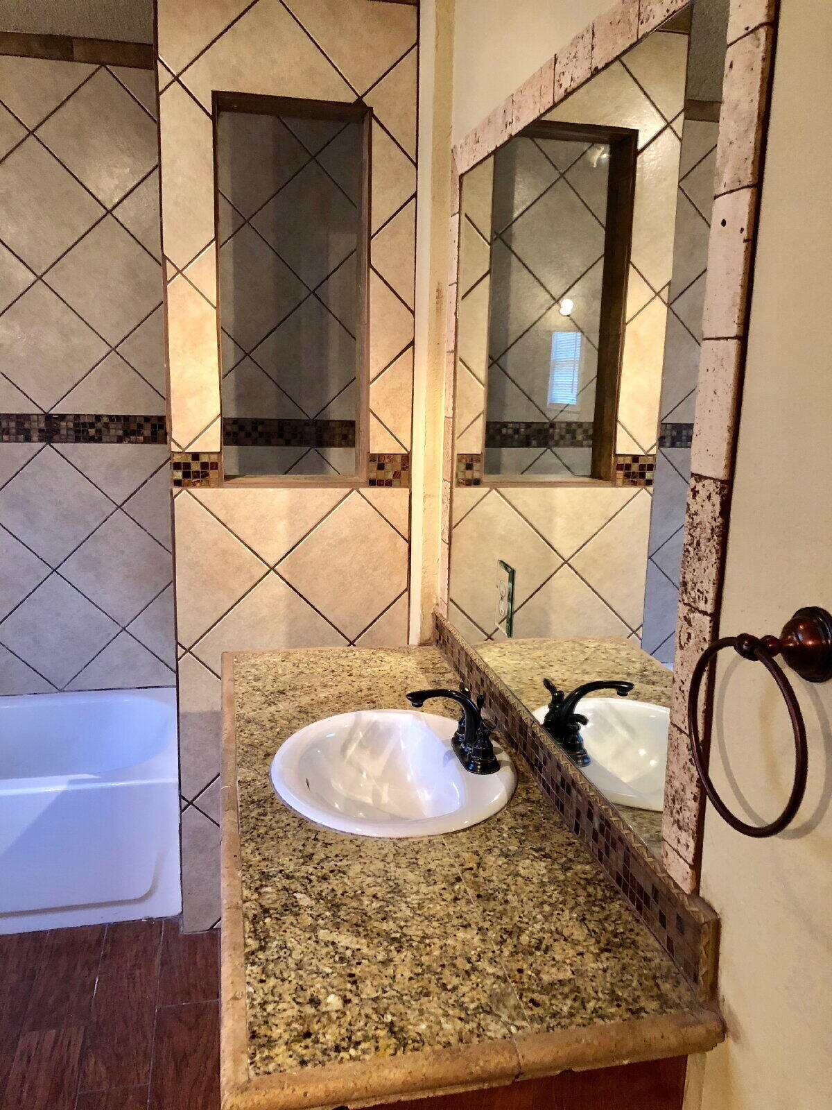 3412 30th Street Lubbock, TX 79410 - Photo 12 of 14 a bathroom with a sink and a mirror