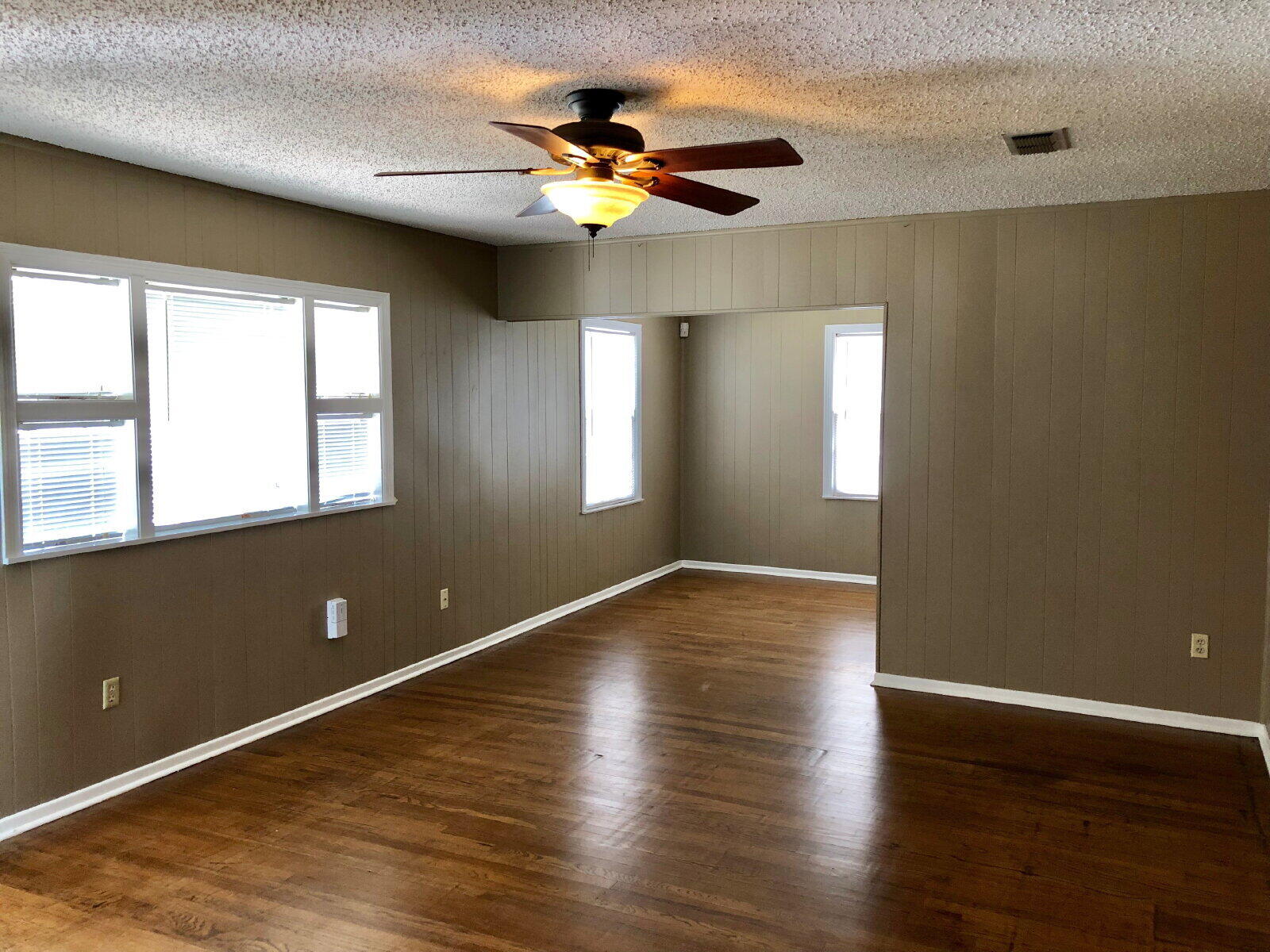 3412 30th Street Lubbock, TX 79410 - Photo 2 of 14 a view of an empty room with wooden floor and a window
